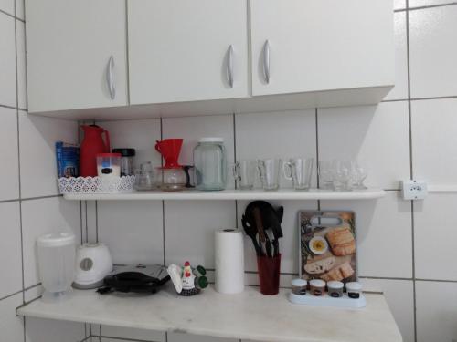 een keuken met witte kasten en een aanrecht met eten bij Casa pertinho da praia in Paulista