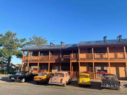 a group of old cars parked in front of a building at Bestes apartamenti in Kocēni