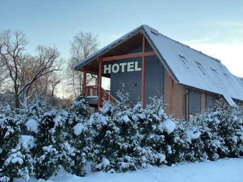 a hotel building with a snow covered roof at Bestes apartamenti in Kocēni