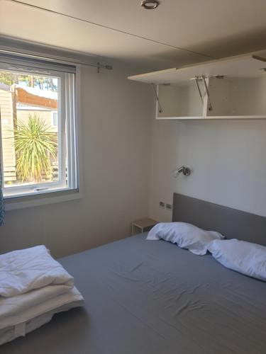 Un pat sau paturi într-o cameră la Mobil Home Comfort XL 6 Personnes Montalivet
