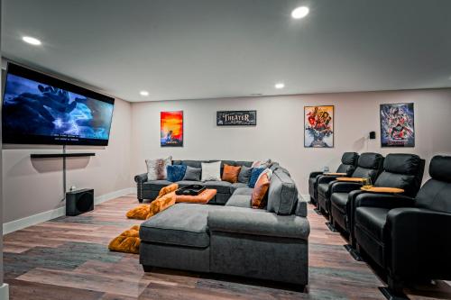 uma sala de estar com sofás e uma televisão de ecrã plano em Sauna - Hot Tub - Theater - Arcade - Family Fun em Massanutten