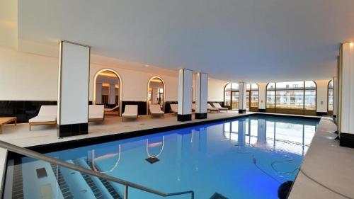 - une grande piscine dans un bâtiment avec des chaises dans l'établissement L'intemporel plage - Malo'Cation, à Dunkerque