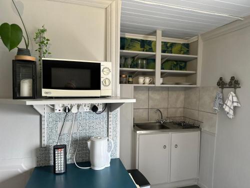 a kitchen with a counter with a microwave and a sink at Welgemoed Villa in Bellville
