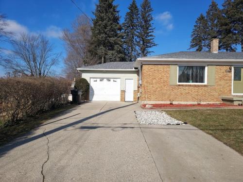 a brick house with a garage and a driveway at The Lodge Near Grand Rapids in Kentwood