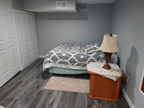a bedroom with a bed and a lamp on a table at The Lodge Near Grand Rapids in Kentwood