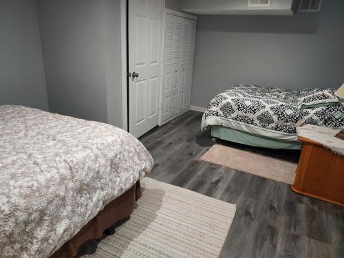 a bedroom with two beds and wooden floors at The Lodge Near Grand Rapids in Kentwood