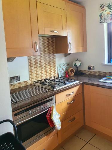 a kitchen with wooden cabinets and a stove top oven at Lindas Retreats Self catering accommodation 1 bedroom cottage or 3 bedroom House in Tomintoul