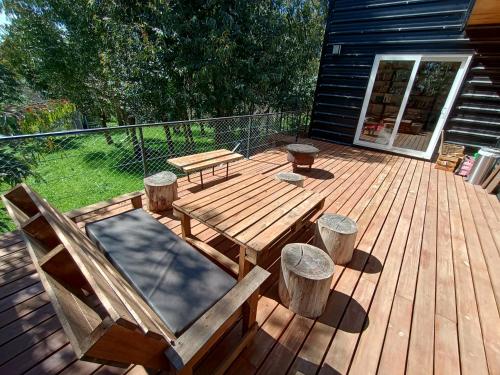 una terraza de madera con banco y mesa de picnic en EcoHaus en la sierra en Tandil