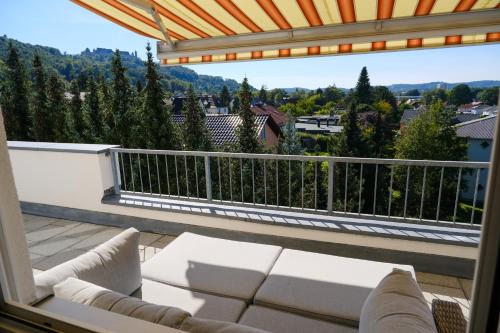 a patio with a couch and a balcony with a view at Vesteblick-Penthouse in Coburg