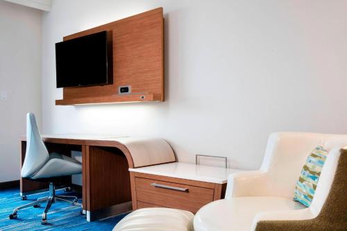 a room with a desk and a tv and a chair at Courtyard by Marriott Faro Blanco Resort in Marathon
