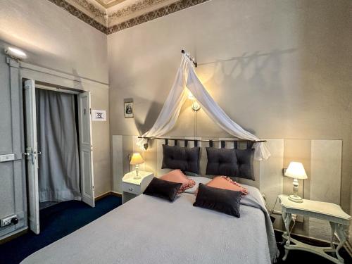 Guest House Santa Giustina Lucca Centro Storico في لوكّا: غرفة نوم بسرير كبير مع مظلة