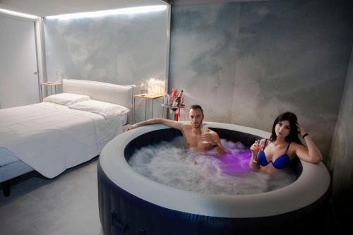 a man and a woman in a bathtub in a bedroom at IL FIORE DI SPINA in Spina