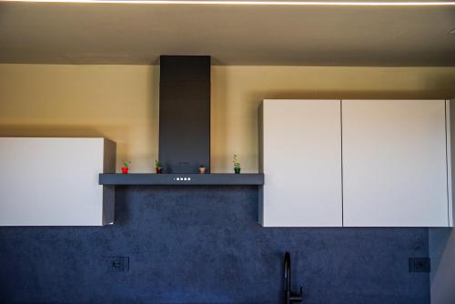 a kitchen with white cabinets and a counter top at Vista Langhe - CerratoHouses in Guarene