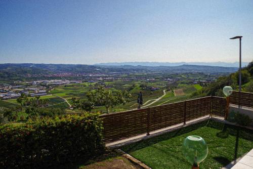a view of a valley from a balcony with a wine glass at Vista Langhe - CerratoHouses in Guarene