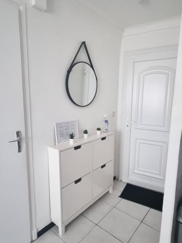 a white bathroom with a mirror and a white dresser at Appartement coquet Le Boulou in Le Boulou
