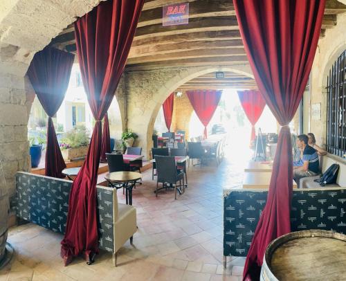 モントレアルにあるVictorian Lodgeの赤いカーテンとテーブルと椅子が備わるレストラン
