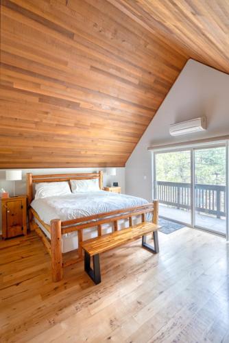 a bed in a room with a wooden ceiling at Welcome to The Village Hideout, Steps to the Village, Resort, Golf, SHARC, AC, Hot-tub, Grill and Bikes in Sunriver