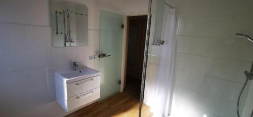 uma casa de banho branca com um lavatório e um chuveiro em Ferienwohnung,Unterkunft Blick Rappenstein em Hausen am Tann