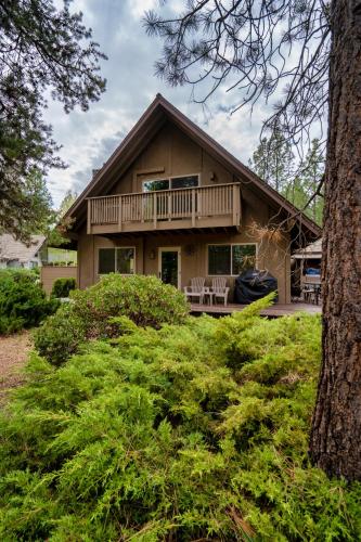 a house with a wrap around porch with a deck at Welcome to The Village Hideout, Steps to the Village, Resort, Golf, SHARC, AC, Hot-tub, Grill and Bikes in Sunriver