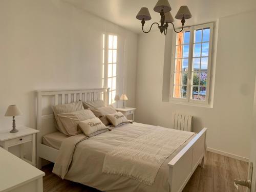 une chambre blanche avec un grand lit et une fenêtre dans l'établissement Appartement neuf en centre ville, à Trouville-sur-Mer