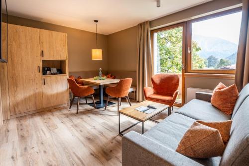 a living room with a couch and a table at Das Bayrischzell Familotel Oberbayern in Bayrischzell