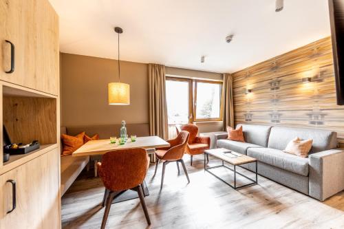 a living room with a couch and a table and chairs at Das Bayrischzell Familotel Oberbayern in Bayrischzell