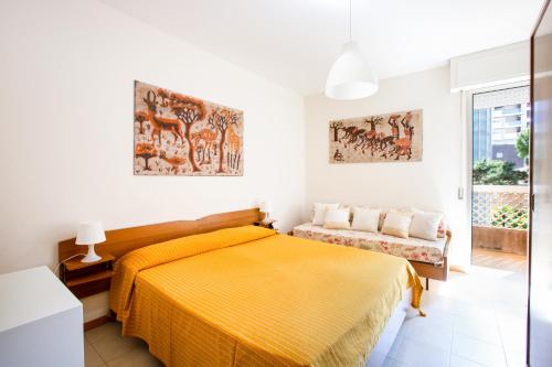 a bedroom with a yellow bed and a window at condominio italia in Lignano Sabbiadoro