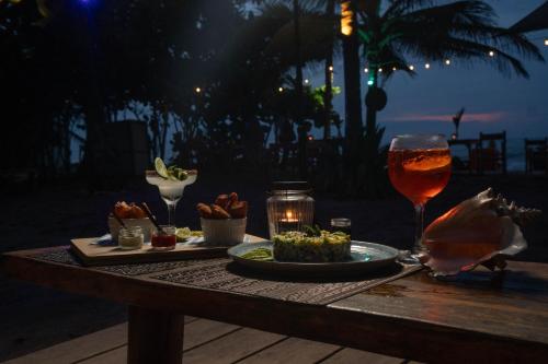 a table with a plate of food and a glass of wine at Casa Chapolin Boutique Guesthouse in Palomino