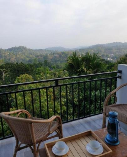 a balcony with chairs and a table with a view at Desire Village Rakwana in Rakwana