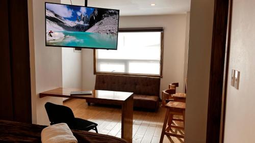 uma sala de estar com uma televisão de ecrã plano na parede em Origenes Apartments em Puerto Natales