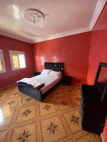 1 dormitorio con 1 cama en una pared roja en THE BLEU TERRE, en Chefchaouen