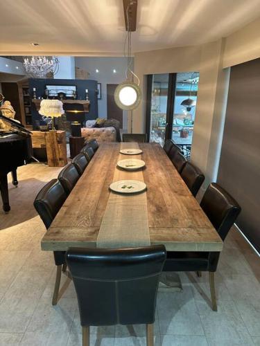 a large wooden table with black chairs and a dining room at Bonshaw Grange-Riverside Country Retreat, & HotTub in Lockerbie