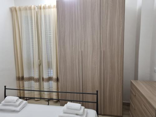 a bedroom with a bed and a wardrobe with towels on it at La casa di Laura in Tortolì