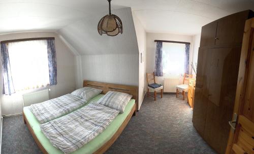 a bedroom with a bed and a chair in it at Ferienwohnung Tanja in Lassan