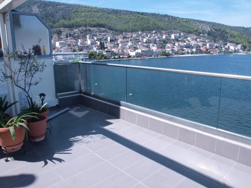 a balcony with a view of the water and a city at NINEMIA in Amfilochía