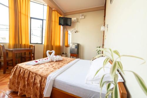Un dormitorio con una cama con una flor. en La Torre Valsai, en Puerto Maldonado