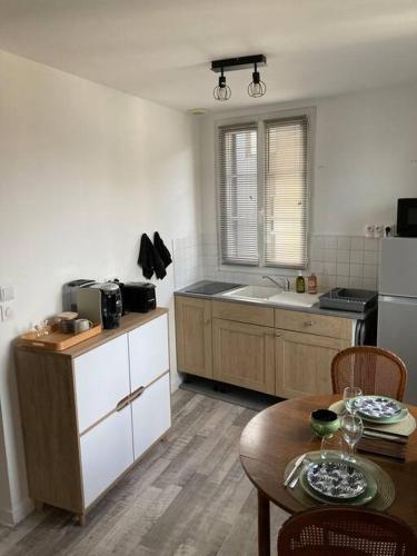 Il comprend une cuisine équipée d'une table et d'un réfrigérateur. dans l'établissement COSY appartement hyper centre, à Bernay