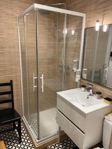 La salle de bains est pourvue d'une douche et d'un lavabo blanc. dans l'établissement AU 47 ALLÉES D'ETIGNY - CENTRAL & STANDING - avec parking - Linge de lit et de toilette inclus, à Luchon