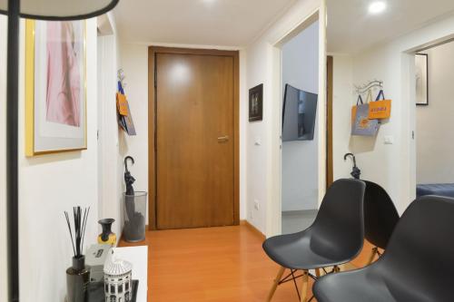 ミラノにあるMilano Lightsの黒い椅子2脚と木製のドアが備わる部屋