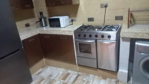 a kitchen with a stove and a microwave at Victorus Homes in Freetown