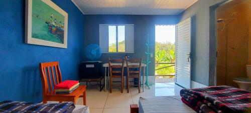Habitación azul con mesa y comedor en Rancho Acácia São Roque, en São Roque