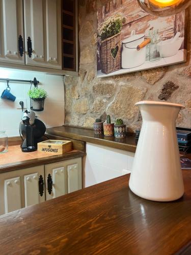 a kitchen with a table with a vase on the counter at El latido del Tiétar in Lanzahita
