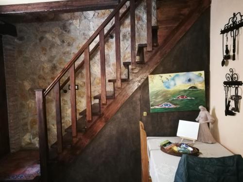 a staircase in a room with a table and a painting at Casa Rural Los Girasoles in Iznatoraf