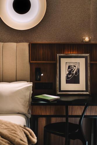 a bedroom with a bed and a table with a picture at Hotel Pinar Plaza in Madrid