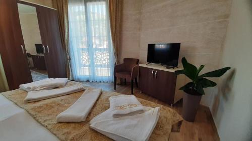 a hotel room with two beds and a television at Prenoćište-Sobe My Place in Novi Pazar