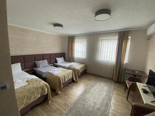 a hotel room with two beds and a desk at Prenoćište-Sobe My Place in Novi Pazar