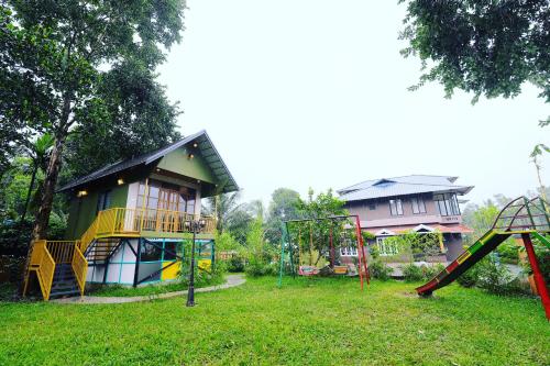 a park with a playground and a house at SKY BLUE HOMESTAY with POOL in Vythiri