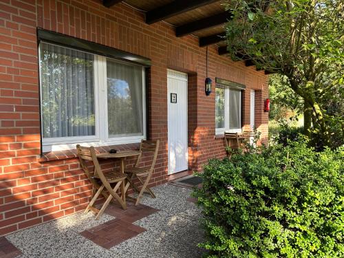 a patio with chairs and a table on a brick house at Waldhotel zum Bergsee Damme in Damme