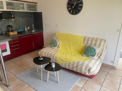 ein Wohnzimmer mit einem Sofa und 2 Tischen in der Unterkunft Valérie in Étampes