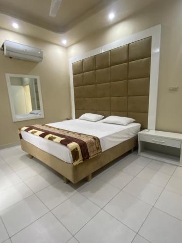 sypialnia z dużym łóżkiem i lustrem w obiekcie The Bahria Town Hotel & Suites w mieście Lahaur